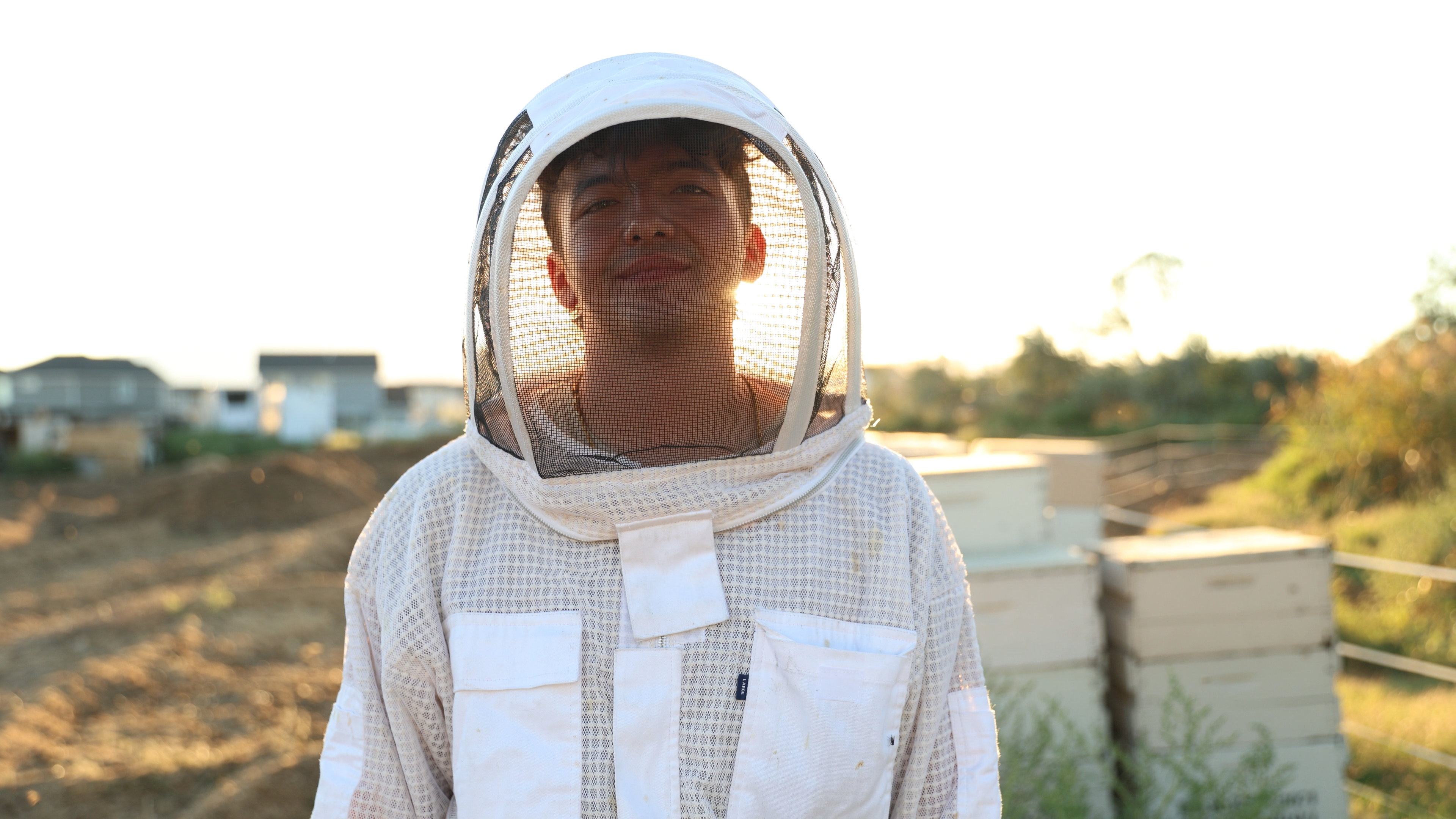 Local Young Utah beekeeper harvesting raw wildflower honey at Amrita Honey Co